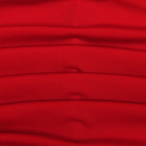 Macro shot of red ruched dress fabric texture showing detailed stitching and material