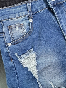 Detalle de pantalones cortos vaqueros de cintura alta azules con rotos y costuras finas
