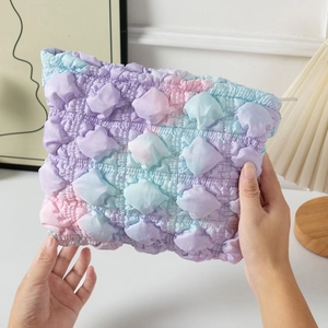 Close-up of cloud-shaped makeup bag featuring puffy textured gradient color fabric