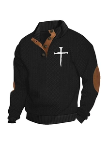 Detail of men's black knit sweater featuring white cross print and brown elbow patches