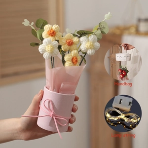 Detail of hand-knitted flower bouquet with pink vase, gift bag and LED string light