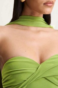 Detailed view of green knit halter dress with cross-chest strap and ribbed texture