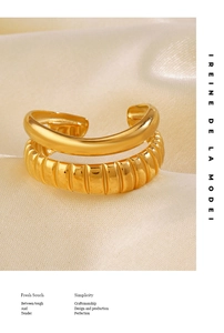 Close-up of double-layered gold open ring on beige silk background with luxury lighting