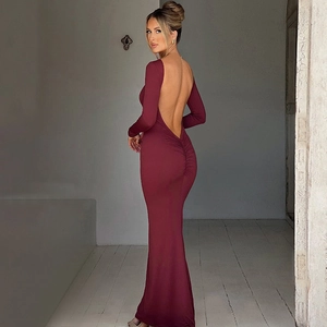 Detail of elegant backless design and ruched details on a slim burgundy maxi dress