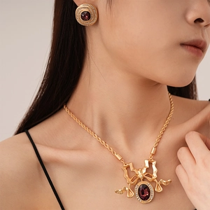 Detail of vintage palace style necklace and earrings with purple gemstones and bow design