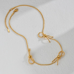 Elegant gold snake chain necklace featuring three minimalist bow pendants with lobster clasp