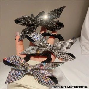Detailed view of handmade bow hair ties featuring sparkling rhinestones in three colors