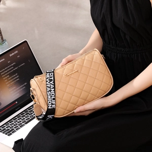 Quilted khaki PU leather shoulder bag with embroidered strap shown in a lifestyle setting