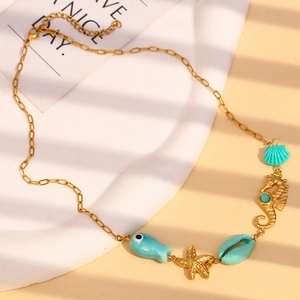 Macro detail of ocean themed necklace with seahorse, starfish and turquoise fish charms