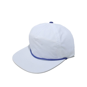 Détail d'une casquette blanche à bord plat avec cordelette bleue et bouton décoratif