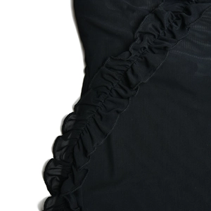 Detailed macro view of black mesh fabric with decorative ruffle and pleated layers