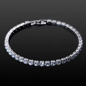Macro view of silver tennis bracelet with round-cut cubic zirconia in prong setting