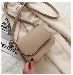 Dettaglio borsa a tracolla beige con scritta argento Fashion Trend sulla patta