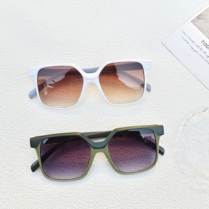 Detail of square frame sunglasses with gradient lenses on white stone texture background