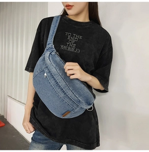 Lifestyle shot of casual blue denim sling bag worn over a black t-shirt for daily commute
