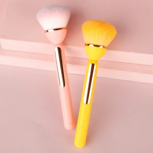 Gradient powder makeup brushes with soft bristles and gold trim on pastel geometric stands