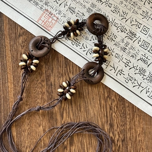 Detailed shot of ethnic necklace with dark wooden rings and beaded woven cords