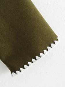 Deep olive green wool jacket with white triangle stitch embroidery and textured fabric