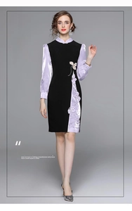 Dettaglio dell'elegante abito cheongsam nero e lilla con raffinato ricamo floreale