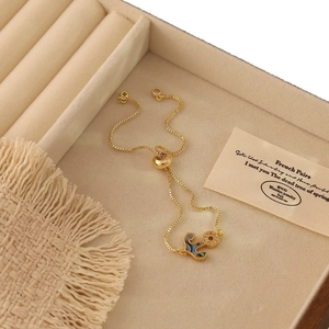 Adjustable gold anchor bracelet with abalone shell inlay and zircons in a jewelry box