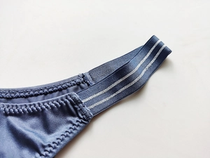 Detailed close-up of blue ice silk low-rise panties with silver striped elastic waistband