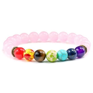 Vue macro de perles de quartz rose 8mm avec sept pierres de chakra colorées et séparateurs bronze