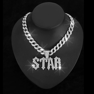 Close-up of iced out silver STAR letter pendant on Cuban link chain for hip hop style