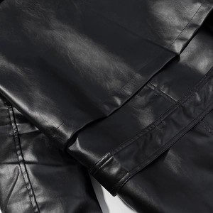 Close-up of premium black PU leather texture with detailed double stitching and seams