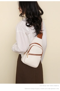 Macro detail of white lychee leather texture and brown trim on a stylish crossbody chest bag