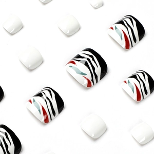 Press-on toenails featuring black and white zebra patterns with red and blue accents