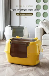 Close-up of fully enclosed cat litter box in yellow and white with matching litter scoop