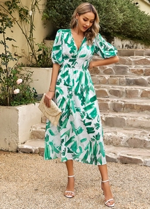 Détail d'une robe mi-longue blanche à col en V avec imprimé abstrait vert et manches