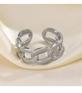 Detailed macro view of silver chain ring with polished finish on elegant silk fabric