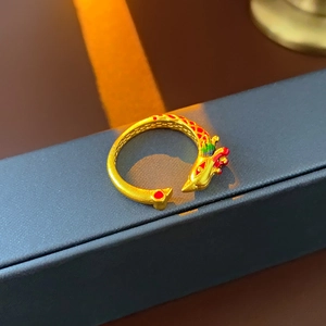 Macro detail of gold dragon phoenix ring with colorful enamel inlay on jewelry box