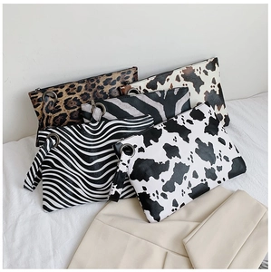 Flat lay of envelope clutches in leopard, zebra, and cow prints with wristlet straps