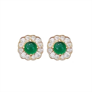 Close-up of gold petal earrings with round emerald stone and diamond accents