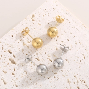 Minimalistisches Set aus hohlkugelförmigen Ohrsteckern in Gold und Silber auf Stein