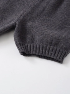 Macro shot of dark grey knit texture showing high-density ribbed cuffs and wool blend fabric
