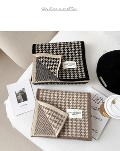 Detailed close-up of knitted houndstooth scarves in black and brown with premium texture