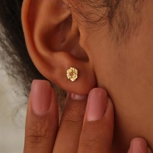 Minimalist December birth flower stud earrings in gold with a small red gemstone center