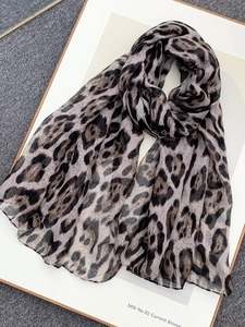 Detail of leopard print scarf showing lightweight fabric texture and brown animal pattern