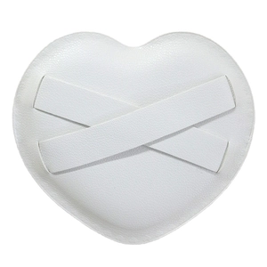 White heart-shaped marshmallow powder puff with textured leather surface and cross straps