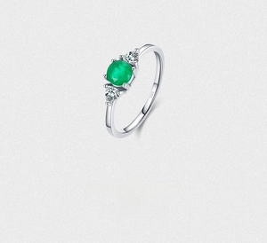 Macro shot of S925 sterling silver ring with emerald stone and pear-shaped side crystals