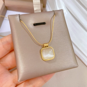 Detailed view of square cat eye stone pendant on golden titanium steel snake chain