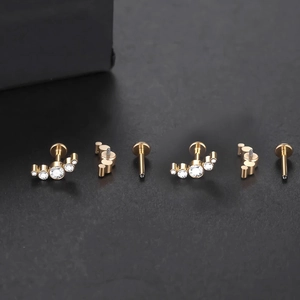 Detail view of gold titanium labret studs with cubic zirconia and internal threading
