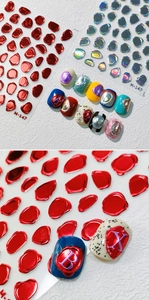 Detailweergave van 5D-nagelstickers met een reliëf van rode metallic waszegels.