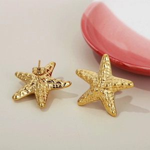 Detailed close-up of golden starfish stud earring with realistic textured metal surface