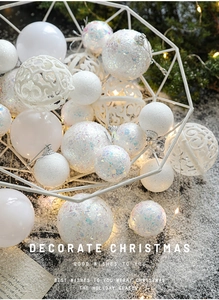 Close-up of assorted white Christmas ball ornaments with glitter and hollow out patterns