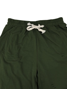 Detail of dark green shorts featuring elastic waist, white drawstring and distressed holes