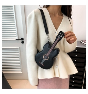 Detail der kreativen schwarzen Gitarren-Umhängetasche mit Saitenmuster und breitem Gurt